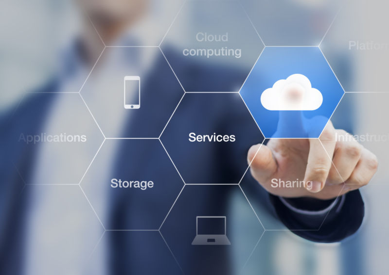 Concept about cloud computing, applications, storage, and services with a businessman touching a button on virtual screen
